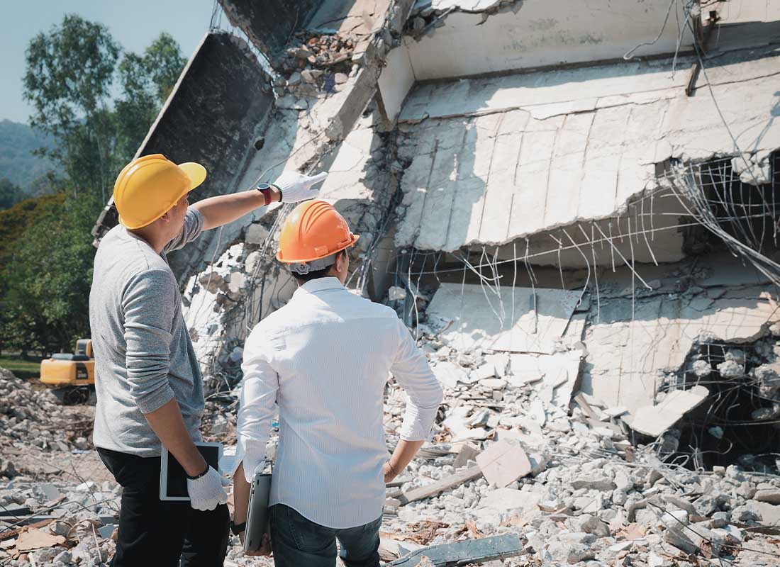 Natural Disaster Insurance - Demolition Control Supervisor and Contractor Discussing Building Condition after a Natural Disaster on a Sunny Day