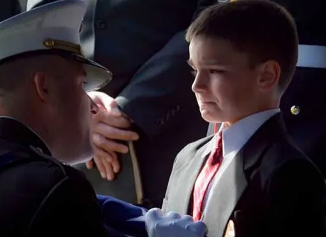 Community Involvement - Soldier Kneeling Down to Look at a Young boy During a Ceremony